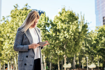business woman in a suit using a tablet