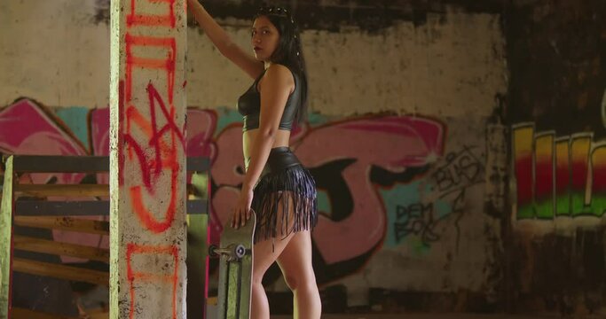 A skateboarder in a mini skirt gracefully glides through an indoor skate park.