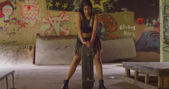 A young female skateboarder in a mini skirt navigates through an indoor skate park.