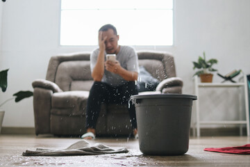 Stressed Man Calling Home Service to Repair Roof Leak at Home. Putting a  Bucket for Water From The...