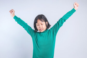 Cute little girl stretching her hand rise up to the air isolated on grey background