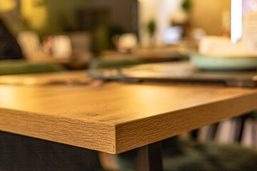 A wooden table in a café , defocused images of people, lights and the cafe interior background