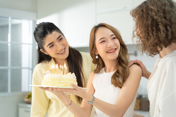Three friends sharing a moment of admiration for a beautifully decorated cake in a modern and...