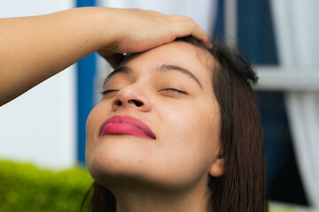 Fototapeta premium Latina mother stylist cutting her daughter's dark hair outdoors. Concept of love and beauty. Mother and daughter.