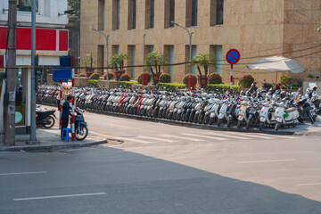 Street with many motorbike, motorcycle scooters parked in row in Hanoi, Vietnam