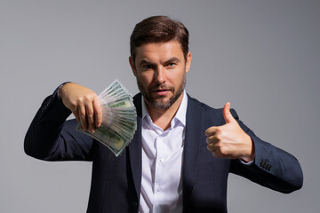 Business man hold money on gray studio isolated background. Rich man in suit with money dollar...