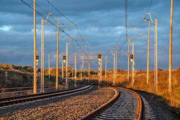 Electric railroad tracks in the light of the setting sun