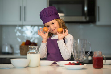 Child chef hold eggs. Kid making tasty delicious. little boy in chef hat and an apron cooking in...