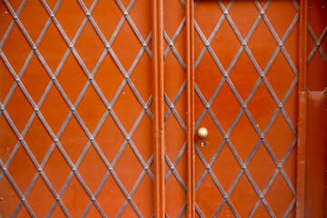 Traditional orange metallic door with diamond metal pattern.