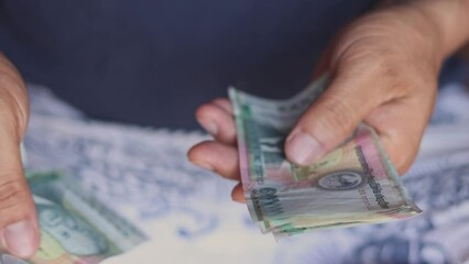 Closeup footage of business man is counting Lao kip currency cash, Lao economy and money reflection concept, hight quality video clip for using - Powered by Adobe