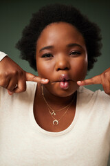 Comic, black woman and funny fish face in studio for comedy or joke isolated on green background. Portrait, lips and crazy model with facial expression, goofy or silly young plus size African student