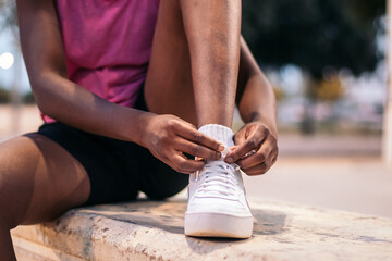 Unrecognizable woman tying her sneakers for sports
