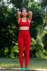 Full length of slim athletic young woman stretching and relaxing in summer park, Forest wellness: A young woman practices yoga alone, stretching amidst lush greenery in summer