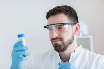 Scientist male with lab glasses working in a laboratory - obrazy, fototapety, plakaty