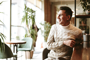 Man in White Sweater Sitting in Chair