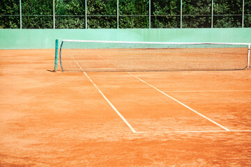 Tennis court with net on a sunny day. Sport field background