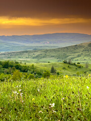 Landscapes of Transylvania. Vertical photo with an amazing sunset over the hills and villages of Transylvania in Harghita county. Travel to Romania country side.