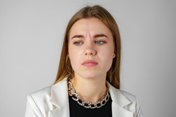 Young Woman Expressing Discontent against gray background
