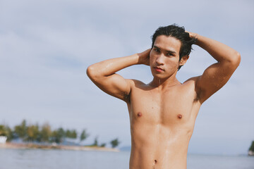 Swim, Splash, and Smile: An Active Asian Man Enjoying a Tropical Beach Vacation