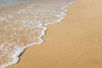 The beach has waves lapping the shore.
