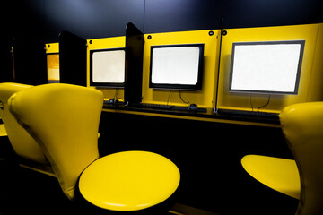 games room with yellow armchairs and monitors on the walls