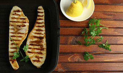 Bistecca di pesce spada alla griglia con limone su tavolo di legno. Concetto di cibo sano. Frutti di mare. Direttamente sopra.