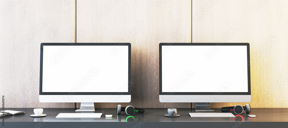Poster Two empty white gaming computer monitors on desk with coffee cups and headsets. Place for your advertisement. Gaming club concept. Mock up, 3D Rendering.