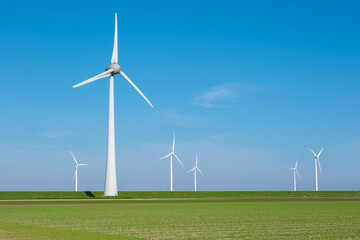 In the picturesque landscape of Flevoland, wind turbines gracefully spin in the green field,...