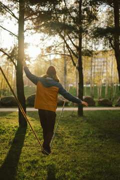 Athletic man trains on a slackline.