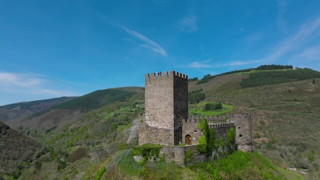 Medieval Doiras Castle With Green Mountain Range In The Background In Lugo, Cervantes, Spain. - aerial shot