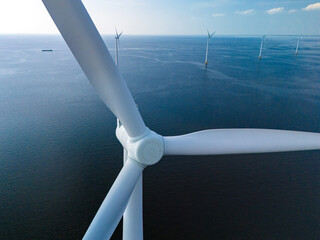 A mesmerizing view of windmill turbines generating clean energy in the vast expanse of the ocean,...
