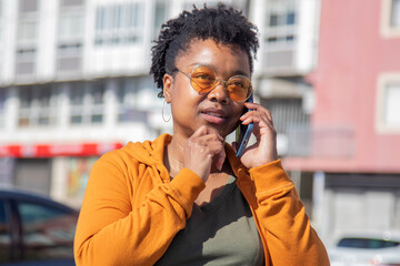 african american woman talking on the phone thoughtfully on the street