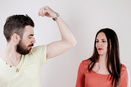 Casual setting, woman smells unpleasant sweat aroma