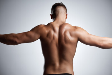 Back, flex and bodybuilder in studio with muscle, fitness and strong from training or exercise....
