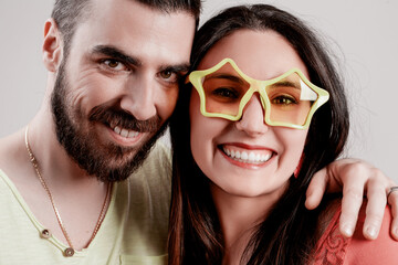Couple smiles; woman wears playful star glasses