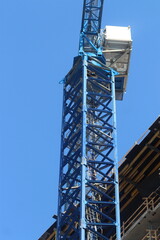 Blue crane in front of building under construction