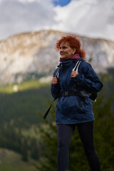 Hiker lady with backpack in the mountains - 808650989