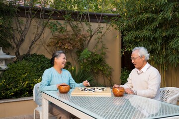 Elderly couple in the yard to play chess