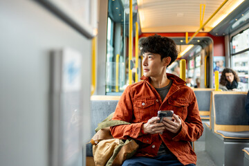 Backpacker traveler man using mobile phone while riding on the train. 