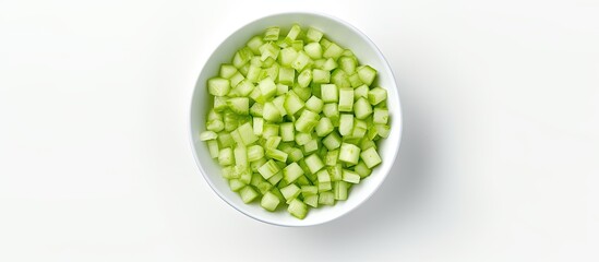 A top down view of a bowl containing diced celery placed on a white table with a plain background There is empty space available for additional images or text