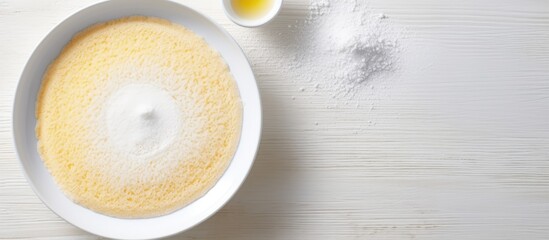A gluten free cake made with corn and rice flour coconut sugar and an egg is being prepared on a transparent plate The dough is being mixed The cake is placed on a white background with copy space fo