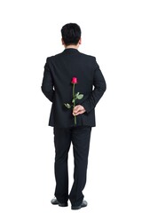 Shed middle-aged business man holding a rose