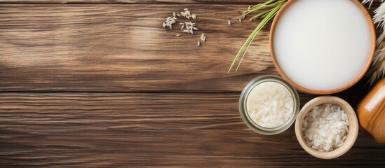 Naklejka premium Flat lay of homemade natural rice water and cosmetic products on a wooden table with ample space for text in the image