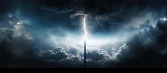 An image with a silhouette of a lightning rod standing out against a backdrop of dark storm clouds providing a perfect copy space - obrazy, fototapety, plakaty
