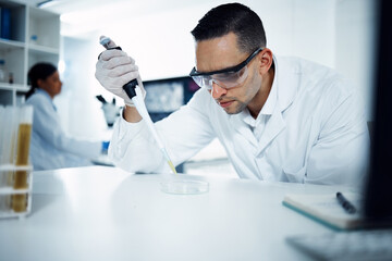 Scientist, man and pipette on petri dish for research, test or chemical analysis for healthcare...