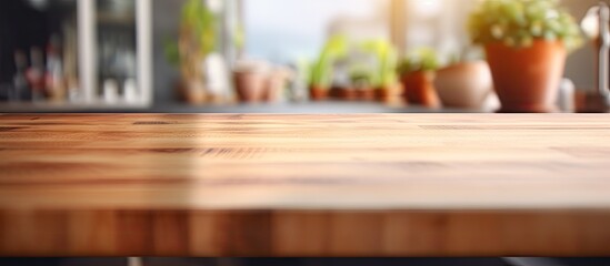 A wooden table top is shown against a blurred kitchen room background in this copy space image perfect for showcasing products or designing key visual layouts