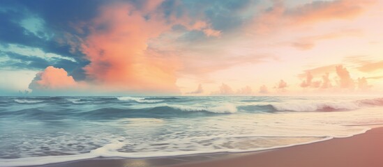 A vintage style color filtered copy space image of a tropical beach where soft sand meets the sea and a picturesque sunset sky with clouds create an abstract background This evokes a sense of freedom