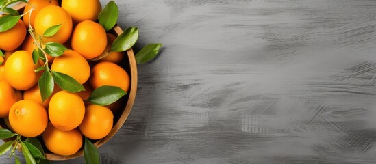 Top view of fresh organic kumquat fruits in a wooden bowl placed on a concrete background The vibrant healthy vegan food is emphasized by the cut up kumquats The image contains plenty of copy space