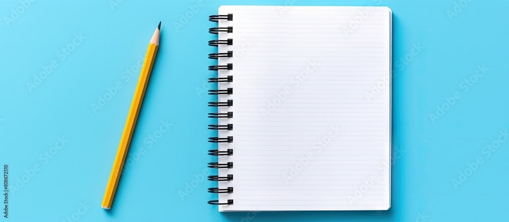 Poster a view from above of an open notebook with a pencil placed on a blue background the notebook has a s