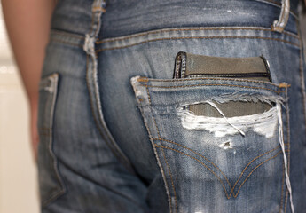 wallet In the back pocket of the broken jeans.